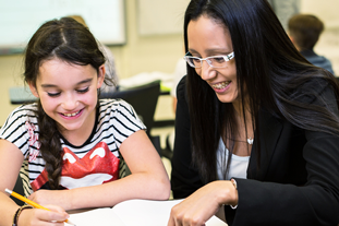 A mentor helping a child do schoolwork.